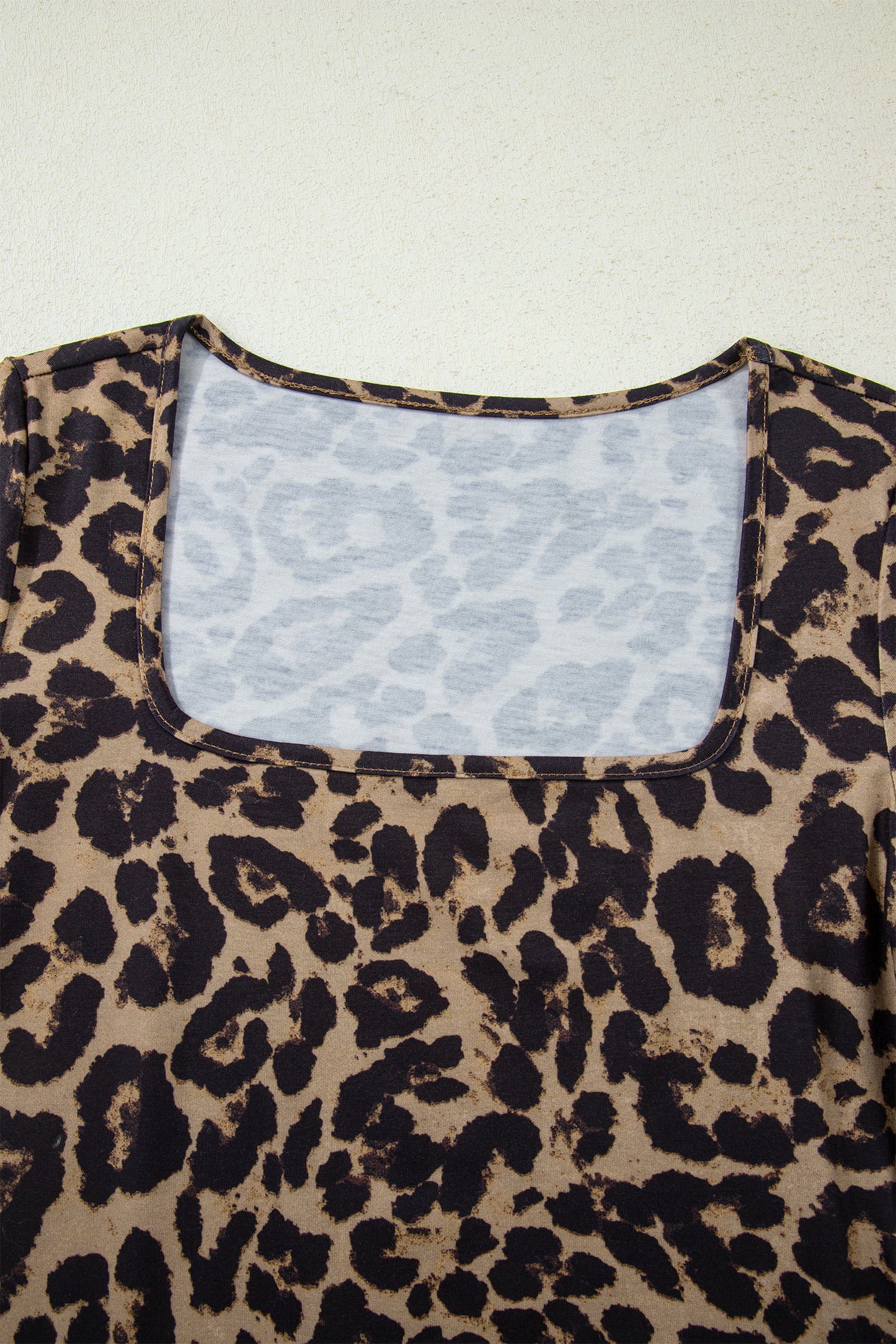 Leopard print top with a white lace lining on a light background