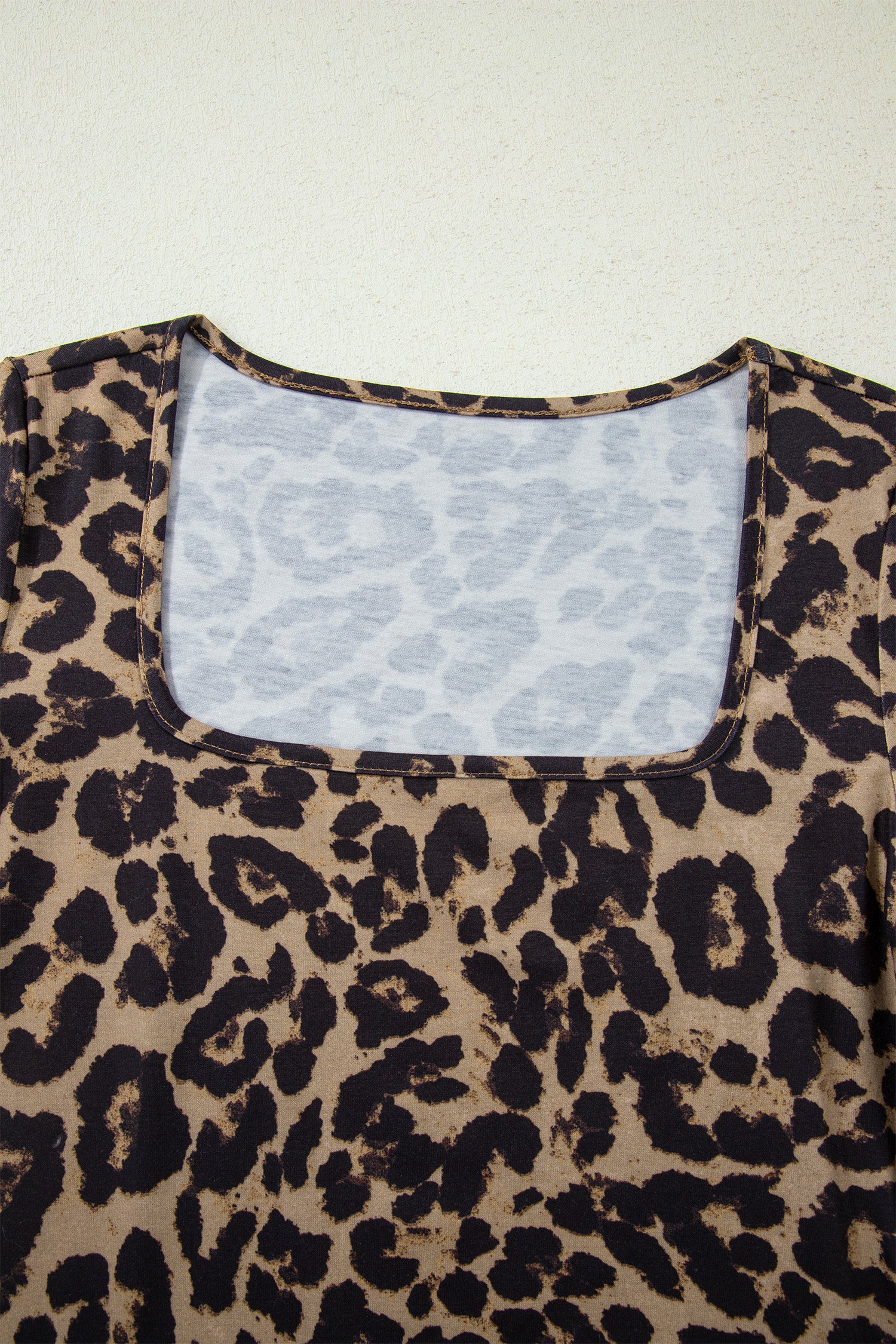 Leopard print top with a white lace lining on a light background